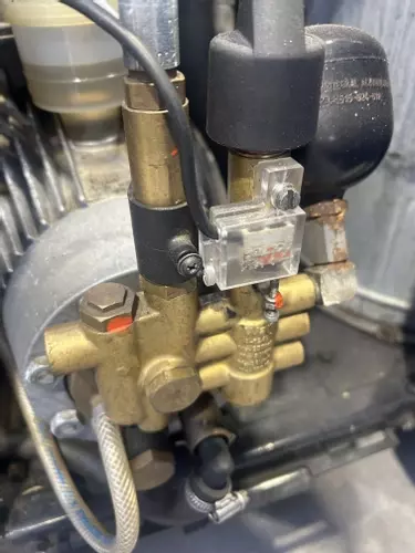 Original Nilfisk Alto unloader valve setup prior to conversion work. Due to extremely heavy daily usage and constant trigger cycling, the customer was experiencing premature unloader wear, leading to the decision to convert the machine to a VB9-style syst